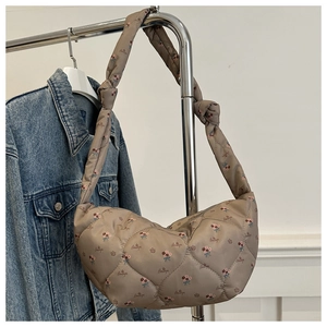 Détail du sac demi-lune en nylon matelassé marron clair avec imprimé floral et nœud