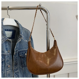 Dettaglio borsa a tracolla semicircolare marrone vintage con catena d'oro e pelle PU