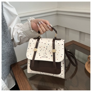 Detailed view of colorful polka dot pattern and Almitv logo on the stylish backpack