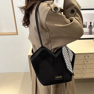 Minimalist black suede tote bag with V-shaped top and geometric silk scarf accessory