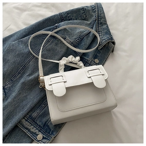 Detail of white PU crossbody bag with pleated scrunchie handle and stylish metal buckles