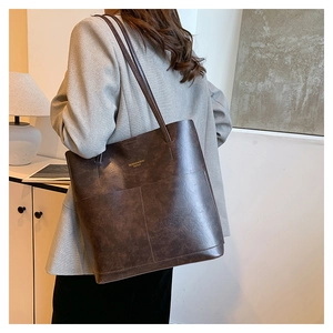 Deep brown large tote bag with leather texture and thin straps for shoulder wear