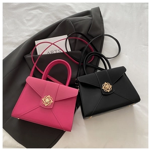 Detail of structured leather handbags with golden floral lock and detachable strap