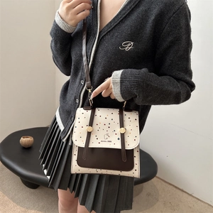 Vintage polka dot backpack with cream flap and dark brown body for a casual college style
