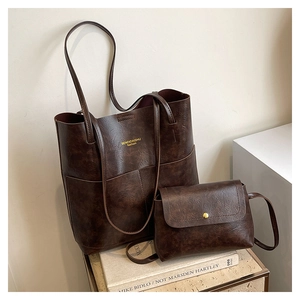 Detail of vintage brown tote bag set with textured leather and gold metallic hardware