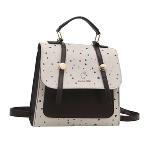 Minimalist white polka dot backpack for women with brown leather trim and Aimity 1986 logo