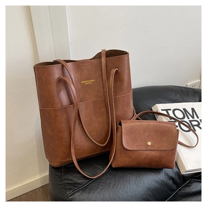 Detail view of large brown tote and matching crossbody flap bag with golden buckle