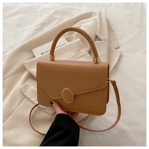 Détail du petit sac carré en cuir marron clair avec boucle ovale dorée élégante