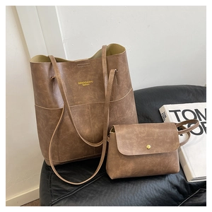 Close-up of vintage brown tote bag set with textured synthetic leather on black sofa