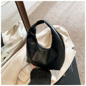 Detail of black hobo bag with geometric stitching and soft leather texture finish