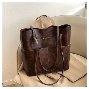 Detail of vintage brown tote bag leather texture with gold brand lettering on the side