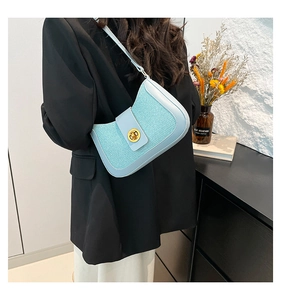 Détail du sac bandoulière en tweed bleu clair montrant le fermoir doré et le cuir