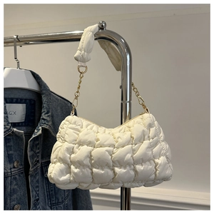Detailansicht der weißen gesteppten Puffertasche mit goldener Kette und weichem Stoff