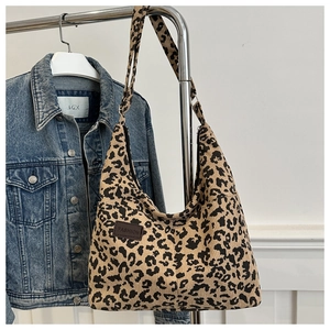 Dettaglio della borsa tote leopardata in velluto a coste con etichetta FASHION in pelle