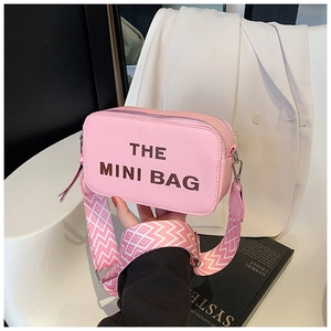 Detail of pink mini bag with The Mini Bag lettering and geometric woven strap