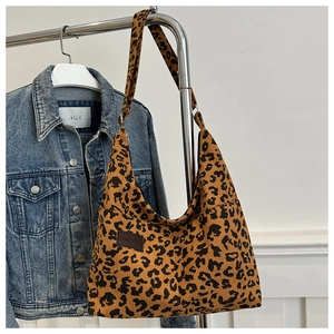 Dettaglio della borsa tote leopardata in velluto a coste con trama e etichetta moda