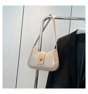 Détail du sac beige pailleté avec fermoir rotatif doré et fine bandoulière élégante