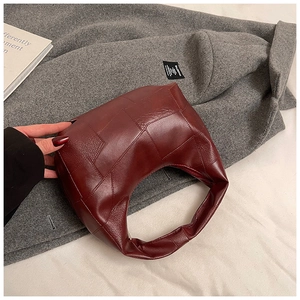 Detailed view of burgundy hobo bag with geometric leather patchwork and grain texture