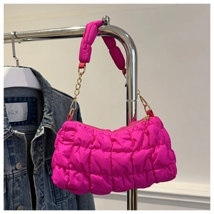 Detail der fuchsiafarbenen Stepptasche mit Blasenstruktur und Metallkettenakzent