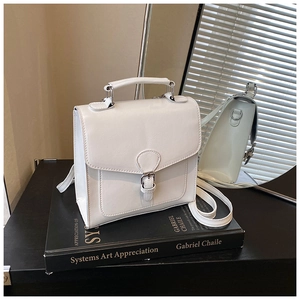 Detailed close-up of white PU leather square handbag with flap and buckle closure
