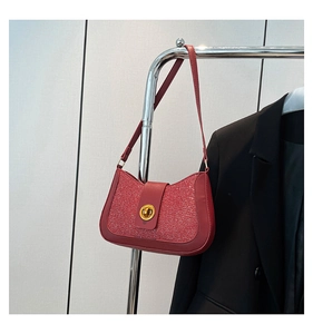 Détail du sac rouge scintillant avec fermoir doré ovale et bordure en cuir