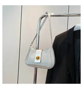 Détail du sac à bandoulière en paillettes argentées avec fermoir doré et bordure métallique