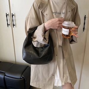Minimalist black leather patchwork Hobo bag shown on a model in a casual outfit