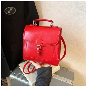Detail of red square PU leather bag with vintage belt buckle and silver handle
