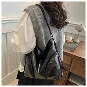 Detailed back view of a woman wearing the large black PU leather tote bag with zip pocket