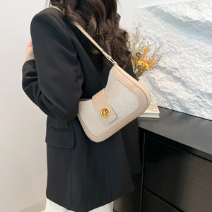 Minimalist beige woven patchwork underarm bag with gold rotating lock and leather strap