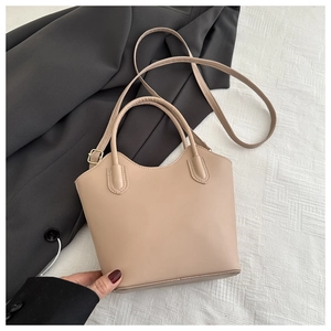 Detail view of beige bucket bag made of matte faux leather with adjustable strap and handles