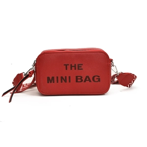 Red textured leather camera bag with wide geometric strap and THE MINI BAG print