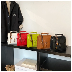 Detail showing five vintage-style square handbags in white, red, green, brown, and black