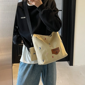 Chic beige canvas bucket bag with colorful embroidery and wide shoulder strap