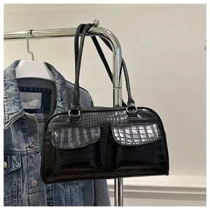 Detail of black faux leather handbag with crocodile pattern and front double pockets