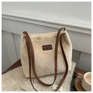 Detail of soft beige faux fur tote bag with brown leather straps and fashion label logo