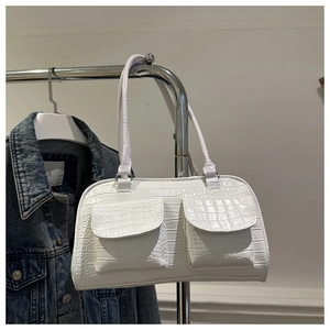Detail of white crocodile pattern underarm bag with double front flap pockets and slim handles