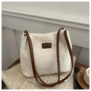 Close-up of fluffy faux fur tote bag with leather logo tag and brown shoulder straps