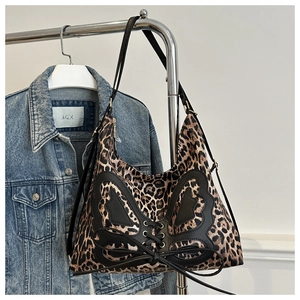Detail of leopard print shoulder bag with black leather butterfly patch and ribbon bow