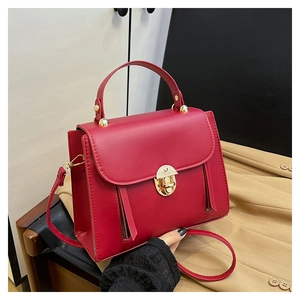 Detail of red PU leather bag featuring a round metal lock and side zipper accents