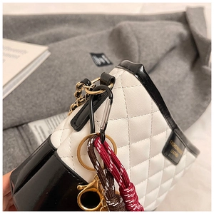 Gros plan sur le sac en cuir matelassé avec bords contrastés et chaîne dorée
