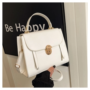 Detail of white PU leather handbag featuring elegant gold twist lock and hardware accents