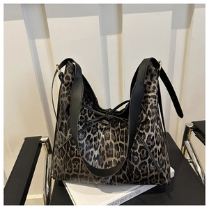 Détail du sac cabas léopard vintage avec un nœud décoratif en cuir noir sur le devant