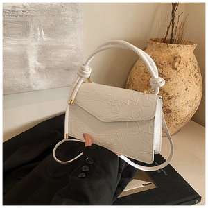 Détail du sac vintage blanc avec motif de lotus en relief et poignée supérieure nouée
