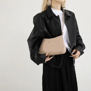 Minimalist beige leather shoulder bag with sleek gold metal accent for elegant women