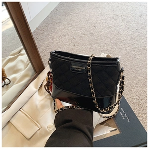 Détail d'un sac hobo matelassé noir avec bandoulière chaîne et logo de mode