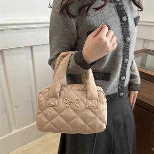 Quilted tote bag with gold bow accent and diamond pattern in beige for women