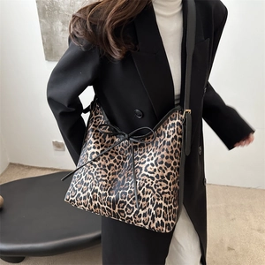 Grand sac cabas à imprimé léopard avec finitions en cuir noir porté par un modèle