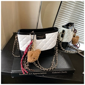 Détail du sac hobo matelassé avec chaîne dorée et charm ours en peluche décoratif