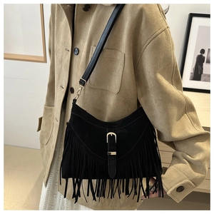 Detail of black fringe shoulder bag with matte texture and metallic buckle belt detail
